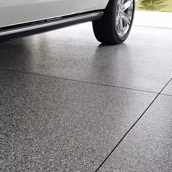 A finished garage floor featuring a textured full-chip multi-layer decorative concrete coating.