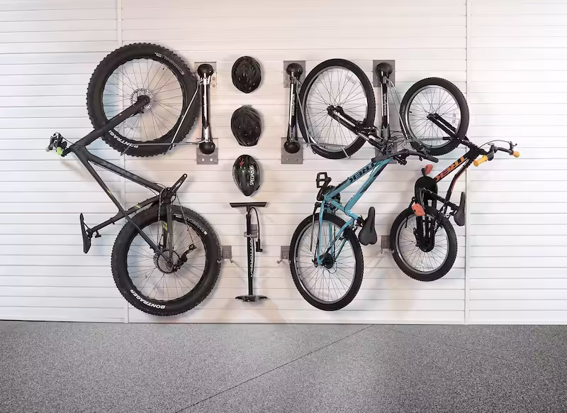 Wall-mounted slatwall panels holding bicycles in a garage.